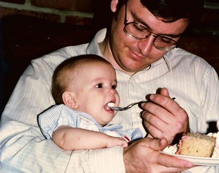 Tom feeding baby Beth some cake