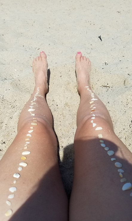 Emily relaxing at the beach with her shells. 